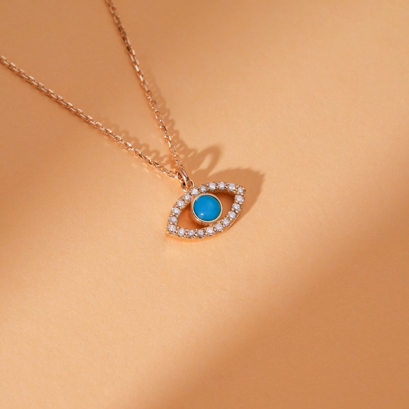 Diamond halo evil eye necklace with a turquoise center on a gold chain