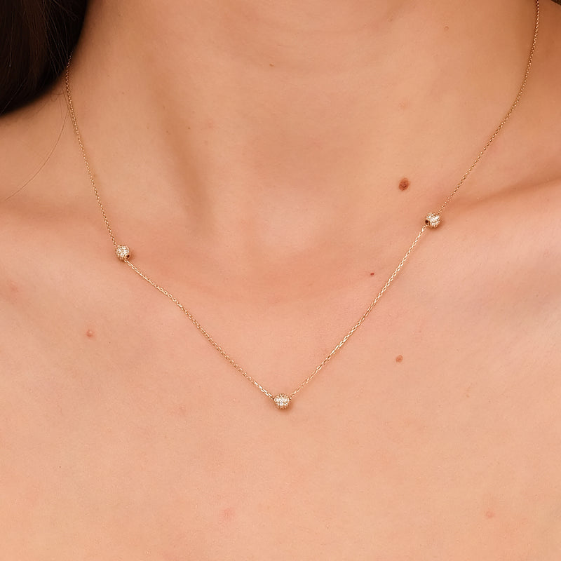 Sparkling pave diamond balls on a gold chain necklace.