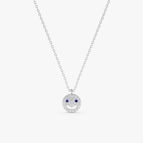 14k solid gold happy face necklace with diamonds and blue sapphires.