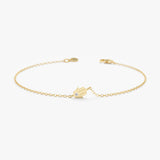 Sideways hamsa bracelet with solitaire diamond in solid gold.