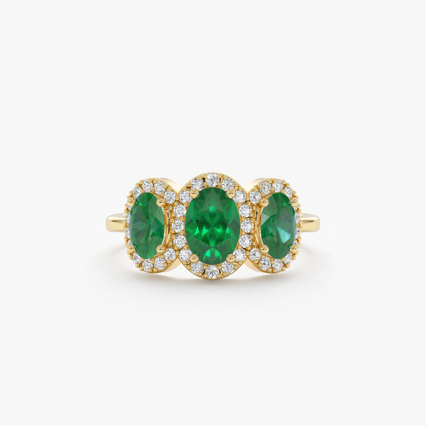 oval emerald engagement ring with diamond frames in yellow gold