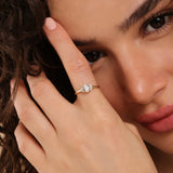 oval cut diamond flanked by diamond accents in 14k solid gold