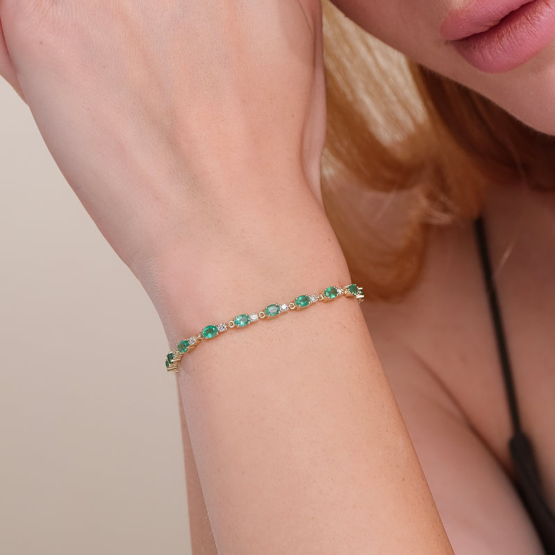 Yellow gold diamond and emerald tennis bracelet