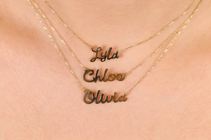 Wear your name in style with a custom solid gold cursive name necklace.