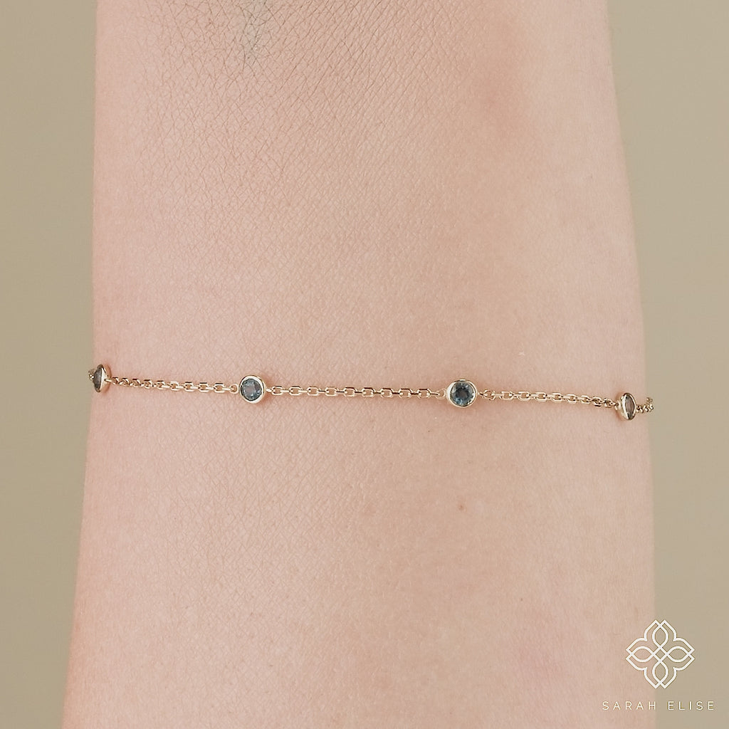 dainty solid gold station bracelet with blue topaz gemstones 