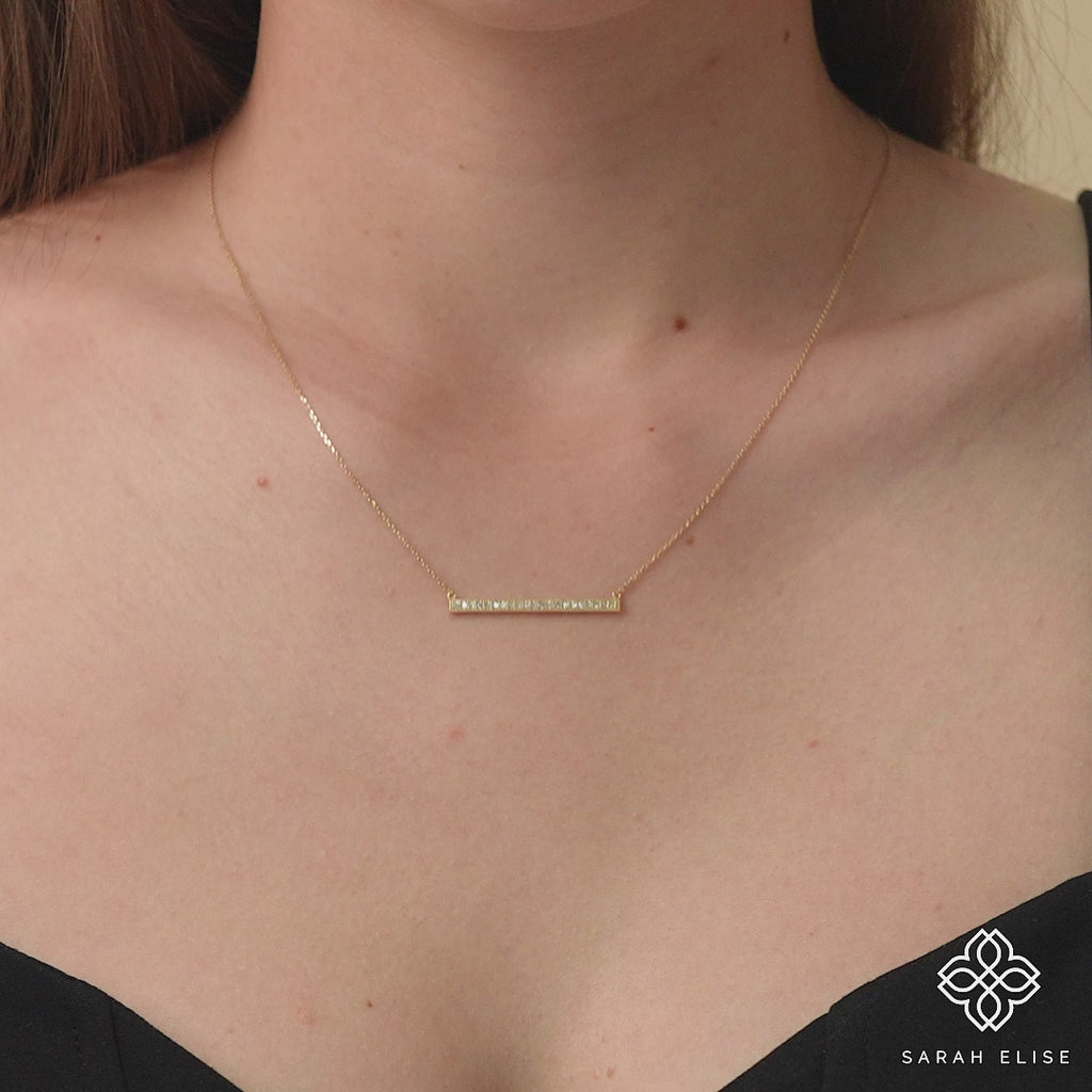 Sleek and modern diamond bar pendant on a gold chain