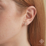 Video close up of model wearing handmade ethically sourced mixed diamond huggie hoop earrings in 14k solid gold