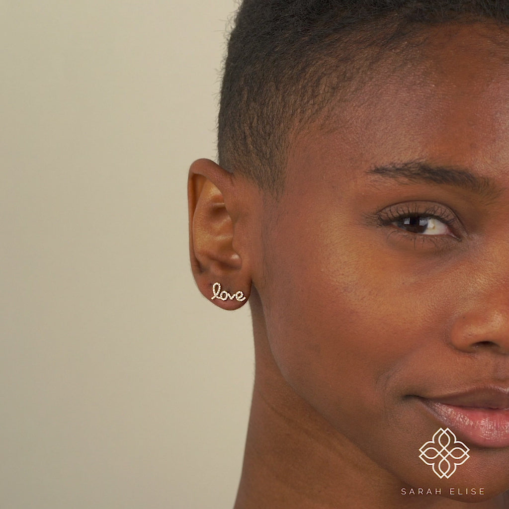 Model wears Handmade 14k solid Gold Cursive Diamond Love Earrings