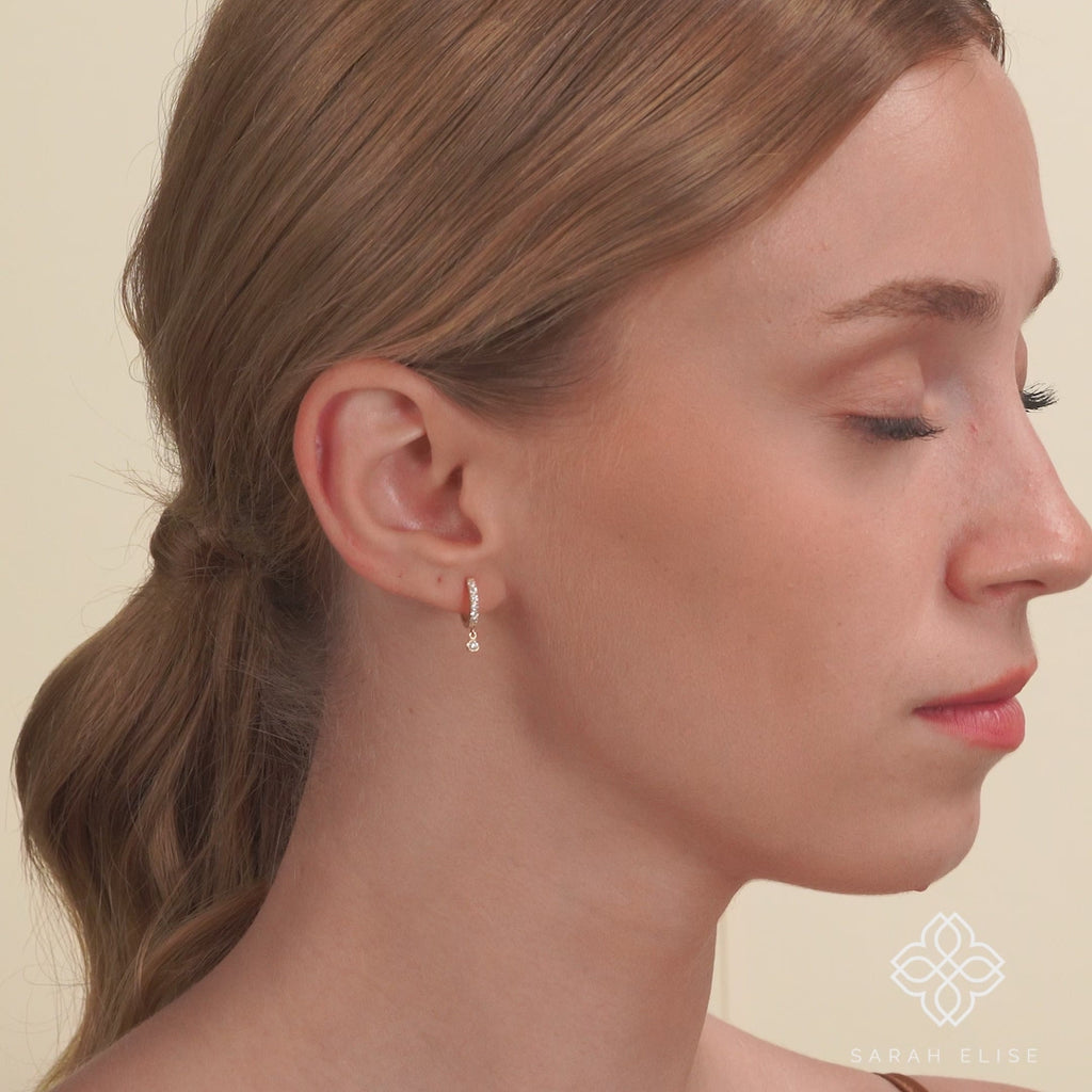 Video close up of model wearing solid gold diamond lined hoop earring