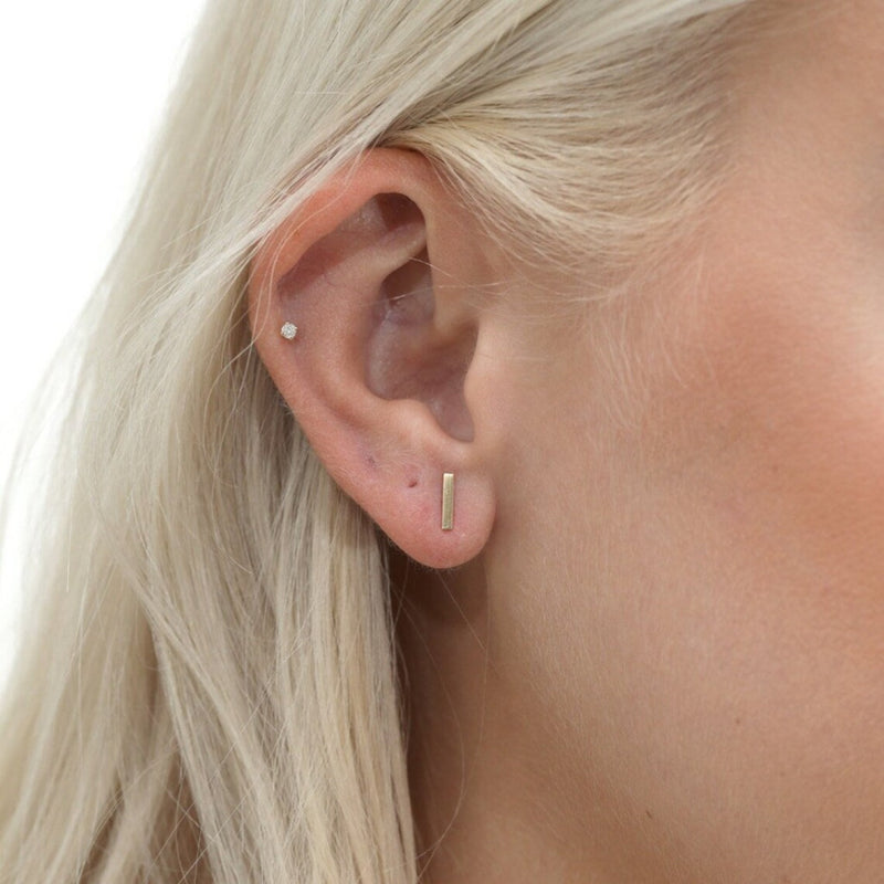 model wears minimalist gold bar stud earring for her